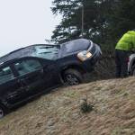 Michael Penn | Juneau Empire  A Capital Towing company employee pulls a vehicle up the embankment at Twin Lakes on Tuesday. The driver suffered minor injuries in the one vehicle accident.
