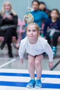 Second-grader Laura Parker, of Riverbend Elementary School, concentrates on her Alaska high kick during the Native Youth Olympics at Riverbend Elementary School on Friday, Feb. 9, 2018. (Michael Penn | Juneau Empire)