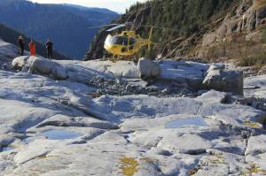 Forest Service Employees inspect the sight of an alpine tsunami on the Cowee Creek Channel. On Dec. 30, 2016, a 30-foot tall tsunami scoured the creek&rsquo;s shoreline, exposing the grey rock in the foreground. (Photo courtesy the U.S. Forest Service and Rick Edwards)