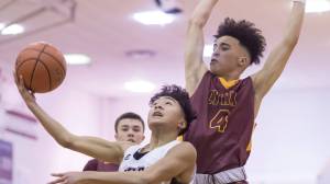 Juneau-Douglas&rsquo; Israel Yadao attempts a layup against Dimond&rsquo;s Isaiah Moses at JDHS on Friday, Feb. 9, 2018. Dimond defeated JDHS 57-53 on Friday and 50-49 on Saturday. (Michael Penn | Juneau Empire)