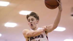Juneau-Douglas&rsquo; Kolby Hoover passes over Ketchikan&rsquo;s ER Caparas at JDHS on Wednesday, Feb. 21, 2018. JDHS won 59-41. (Michael Penn | Juneau Empire)