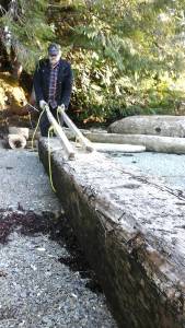 Gary Neilson, the author&rsquo;s father, demonstrates the cradles and handles used to haul the beams to the house. Photo by Tara Neilson.