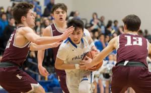 Thunder Mountain&rsquo;s Bryson Echiverri, center, is heavily guarded by Ketchikan&rsquo;s Kyle Smith, left, Kristian Pihl, background, and Cody Kemble at TMHS on Friday, Feb. 23, 2018. Ketchikan won 57-31. (Michael Penn | Juneau Empire)