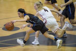 Thunder Mountain&rsquo;s Neal Garcia, left, and Juneau-Douglas&rsquo; Sadie Tuckwood chase down a loose ball at JDHS on Friday. TMHS lost 53-33 on Friday but won 33-29 on Saturday. (Michael Penn | Juneau Empire)