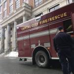 Capital City Fire/Rescue workers return gear to an emergency vehicle in front of the Alaska State Capitol on Thursday afternoon, March 8, 2018. (James Brooks | Juneau Empire)
