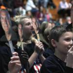 Students hold up pictures of retiring School Resource Officer Blain Hatch at a DARE graduation at Dzantik&rsquo;i Heeni Middle School on Tuesday, March 13, 2018. Hatch is retiring this June. (Alex McCarthy | Juneau Empire)