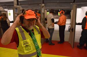 Range officer Bruce Bowler dons his hearing protection before two teams participate in the pistol-shooting competition at the 21st annual Legislative Shoot on Saturday, March 17, 2018 at the Juneau Gun Club. (James Brooks | Juneau Empire)