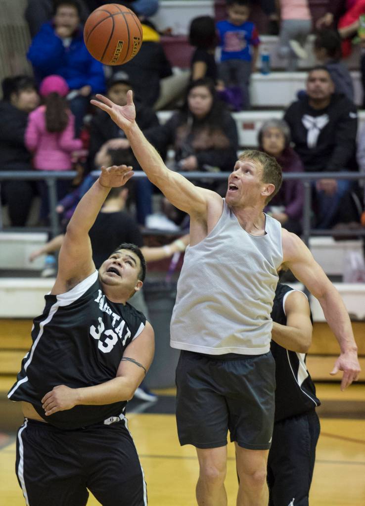 Juneau Crush&rsquo;s Joshua Dean, right, rebounds over Yakutat&rsquo;s Ralph Wolfe during their C bracket game in the Juneau&rsquo;s Lion&rsquo;s Gold Medal Basketball Tournament at Juneau-Douglas High School on Tuesday, March 20, 2018. (Michael Penn | Juneau Empire)