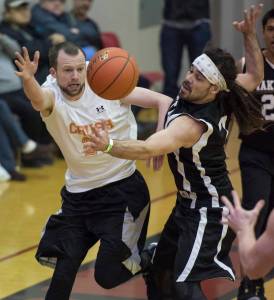 Juneau Crush&rsquo;s Alex Heuman passes around Yakutat&rsquo;s JP Buller during their C bracket game in the Juneau&rsquo;s Lion&rsquo;s Gold Medal Basketball Tournament at Juneau-Douglas High School on Tuesday, March 20, 2018. (Michael Penn | Juneau Empire)