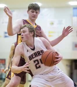In this Feb. 9 photo, Juneau-Douglas&rsquo; Erik Kelly drives inside against Dimond&rsquo;s Evan Hoosier at JDHS. (Michael Penn | Juneau Empire File)