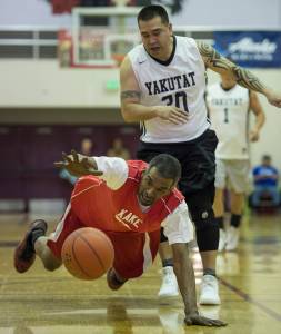 Kake&rsquo;s Kip Howard dives for the ball in front of Yakutat&rsquo;s Frank Jack in the Masters bracket in the Juneau Lion&rsquo;s Gold Medal Basketball Tournament at Juneau-Douglas High School on Wednesday, March 21, 2018. Kake won 60-50. (Michael Penn | Juneau Empire)