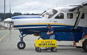 In this May 2014 photo, Mike Scales disconnects an Alaska Seaplanes&rsquo; Cessna Grand Caravan from external batteries before a flight departure at the Juneau International Airport. (Michael Penn | Juneau Empire File)