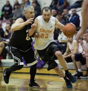 Juneau Crush&rsquo;s Alex Heumann, right, drives against Metlakatla&rsquo;s Archie Dundas in a C bracket game in the Juneau&rsquo;s Lion&rsquo;s Gold Medal Basketball Tournament at Juneau-Douglas High School on Thursday, March 22, 2018. (Michael Penn | Juneau Empire)