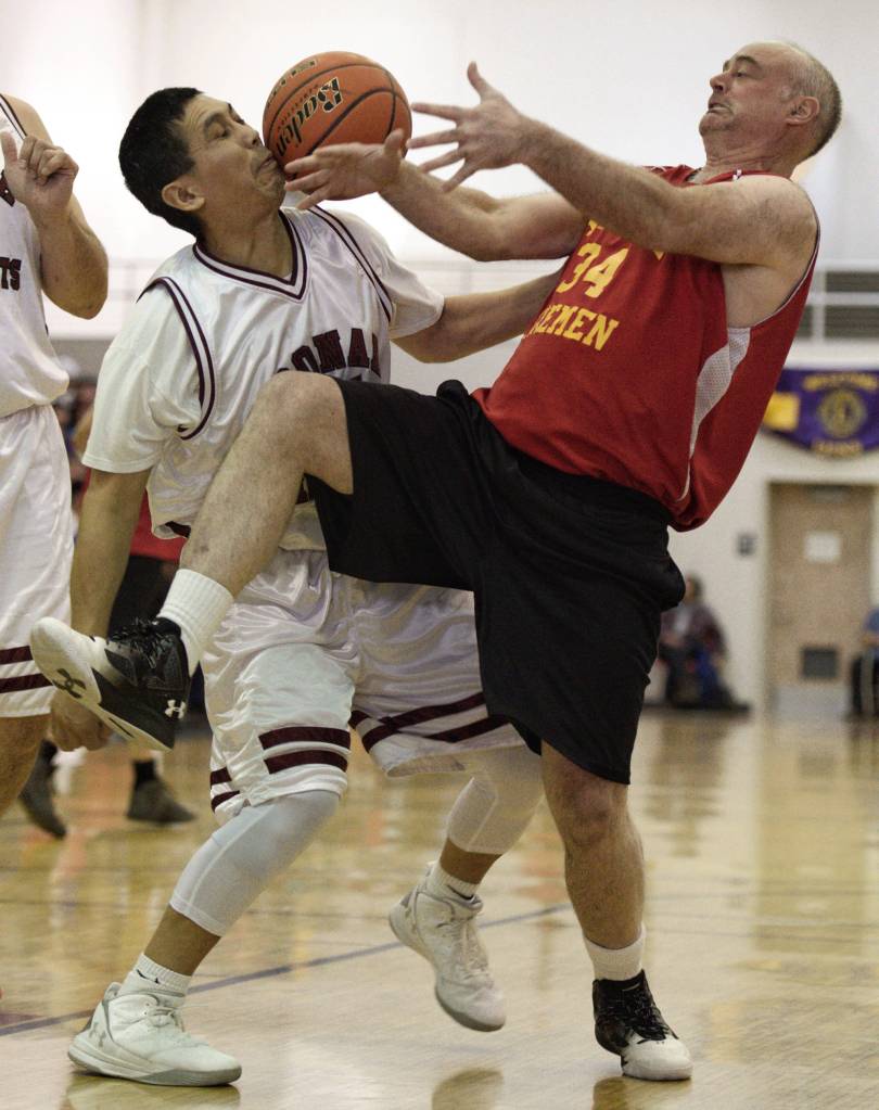 Hoonah&rsquo;s Kin Willard Jr., left, and Kake&rsquo;s Jeff Dean fight for a rebound in the Master&rsquo;s bracket final at the Juneau Lion&rsquo;s Gold Medal Basketball Tournament at Juneau-Douglas High School on Saturday, March 24, 2018. (Michael Penn | Juneau Empire)