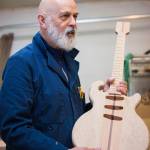George Gress holds up a work in progress&mdash;a solid body electric guitar made of California redwood&mdash;at his Juneau workshop on Tuesday, March 27, 2018. Richard McGrail | For the Capital City Weekly