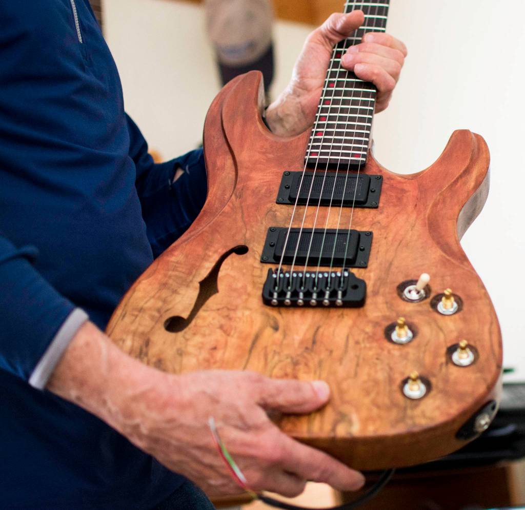 George Gress holds a guitar he made from repurposed wood at his home in Juneau on Tuesday, March 27, 2018. Richard McGrail | For the Capital City Weekly