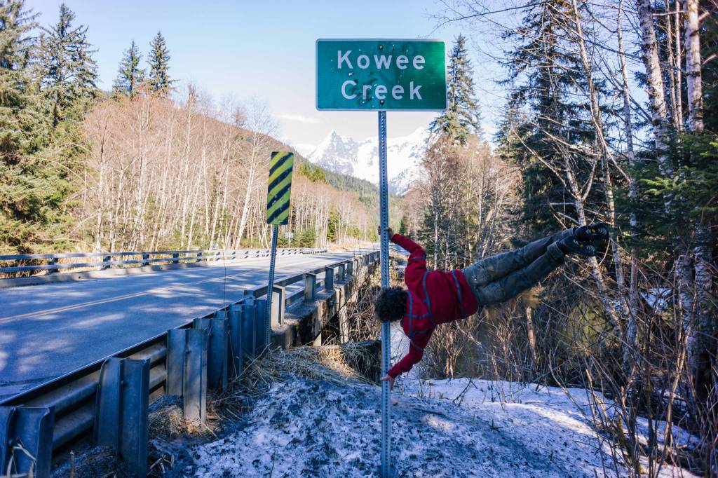 Keagan, the human flag pole on road sign Kowee Creek. (Photo by Gabe Donohoe)