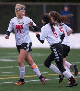 Juneau-Douglas&rsquo; Michaela Bentley, left, celebrates the team&rsquo;s first goal against West with teammates Mariena Romanoff, center, and Eva Gorering at Adair-Kennedy Memorial Field on Thursday, April 19, 2018. (Michael Penn | Juneau Empire)
