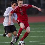 Juneau-Douglas&rsquo; Kanon Goetz is held onto by West Anchorage&rsquo;s Keegan Burke at Adair-Kennedy Memorial Park on Friday, April 20, 2018. West won 3-1. (Michael Penn | Juneau Empire)