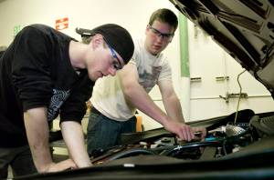 In this May 2009 photo, Josh Smith, left, and Carson Paul, both seniors at Juneau-Douglas High School, work on a car in the school&rsquo;s auto shop as they practice for a state-wide contest in Anchorage. (Michael Penn | Juneau Empire File)