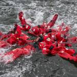 Dzantik&rsquo;i Heeni Middle School students work together to splash as they learn about survival suits from the Alaska Marine Safety Education Association at the U.S. Coast Guard&rsquo;s Station Juneau dock on Monday, April 30, 2018. (Michael Penn | Juneau Empire)