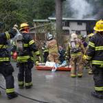 Capital City Fire/Rescue personnel respond to a house fire at 19140 Randall Road on Friday, May 11, 2018. According to Chuck Collins the house was recently bought by his daughter, Brooke, and her husband, Kevin Walker. Collins said the fire started in the attached apartment. (Michael Penn | Juneau Empire)