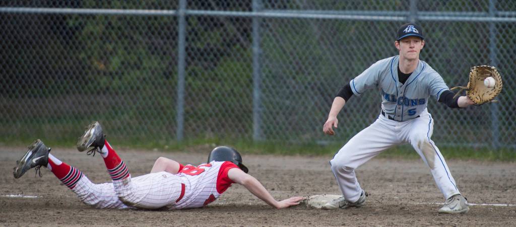 Thunder Mountain&rsquo;s first baseman Logan Lesmann takes a pitch out as Juneau-Douglas&rsquo; Luke Mallinger dives back to first base at Adair-Kennedy Memorial Park on Tuesday, May 15, 2018. (Michael Penn | Juneau Empire)