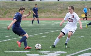 Juneau-Douglas High School senior Brysen Mitchell pressures North Pole&rsquo;s Justin Howard in the ASAA Division II boys soccer state championships, Friday, May 25, 2018. (Nolin Ainsworth | Juneau Empire)