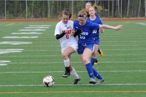Juneau-Douglas High School senior Marlena Romanoff is defended by Palmer High School senior Dory Schneider in Friday&rsquo;s ASAA Division II girls soccer state semifinal game at Palmer High School. JDHS won 7-0. (Nolin Ainsworth | Juneau Empire)