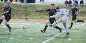 Kenai Central High School&rsquo;s Zach Tuttle shoots while being defended by Juneau-Douglas High School&rsquo;s Ezra Geselle, left, Ronan Davies, middle, and Clem Taylor-Roth, right, in the ASAA Division II state championship game at Anchorage&rsquo;s Service High School on Saturday. Kenai won 3-0. (Nolin Ainsworth | Juneau Empire)