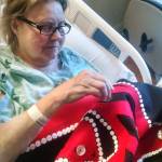 Lynn Alme works on the blanket while in the hospital. Courtesy image.