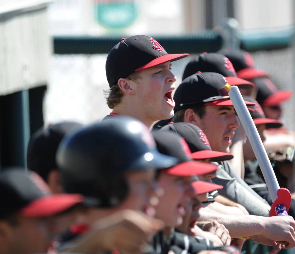 Juneau-Douglas High School baseball player Erik Kelly cheers his team on from the dugout during the ASAA state championship game Saturday. (Michael Dinneen | For the Juneau Empire)