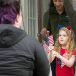 Capital City Fire/Rescue Volunteer Firefighters Antonia Elstad hands out flags to Anna Begenyi, 6, and Kiera Liska during a tour of Douglas properties to judge on Flag Day, Thursday, June 14, 2018. (Michael Penn | Juneau Empire)