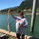 Priscilla Jordan holds up a king salmon caught at Wayside Dock Monday afternoon. (Gregory Philson | Juneau Empire)