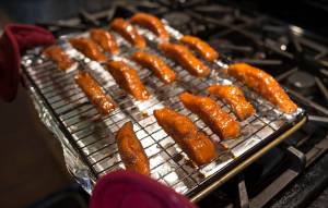 Erin Anais Heist prepares candied chum salmon at her home kitchen on Wednesday, June 27, 2018. (Michael Penn | Juneau Empire)