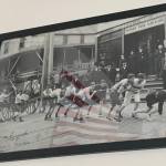 A historic photo dated from 1905 hangs on the wall of the Douglas Fire Station depicting an early Fourth of July hose race. (Alex McCarthy | Juneau Empire)