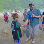 Zane Jones, chair of the Southeast Alaska Section of the American Insititute of Architects, awards a young participant in the Douglas Sandcastle Challenge. (Photo courtesy Zane Jones)