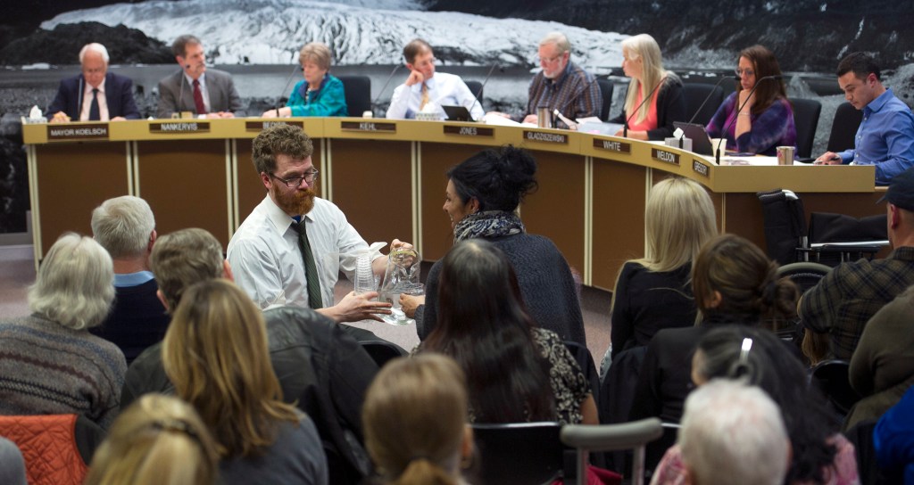 Rep. Justin Parish serves water as Juneau Assembly members take up the Juneau Access Road resolution and an homeless camping ordinance during their meeting on Monday, Jan. 23, 2017. (Michael Penn | Juneau Empire)