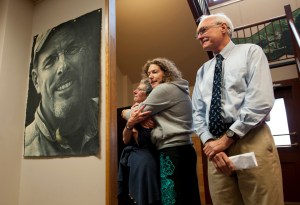 Libby Stortz is comforted by her daughter, Sasha, after unveiling a portrait of her husband, William, Thursday Aug. 18, 2016, at City Hall. William Stortz was working as city building inspector when he was killed in the Aug. 18, 2015, Kramer Avenue landslide. City Administrator Mark Gorman, at right, a close friend of the Stortzes, spoke at the unveiling, congratulating Sitkan Norm Campbell for leading a project to build a display wall in three days. Artist Steve Lawrie spoke about painting the lifelike portrait.