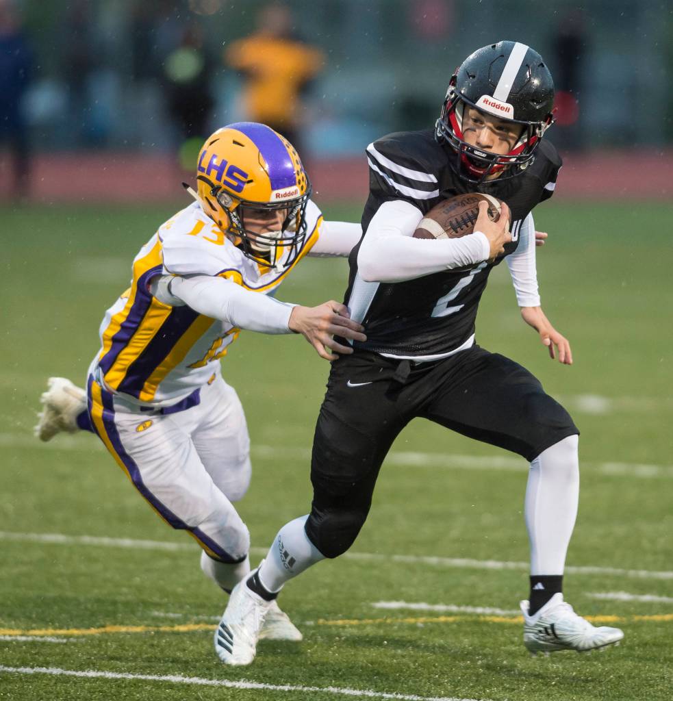Juneau Uniteds Cristian Batac, right, is chased by Lathrops Bubba Maschmeier at Thunder Mountain High School on Saturday. (Michael Penn | Juneau Empire)