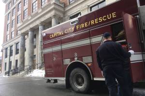 Capital City Fire/Rescue workers return gear to an emergency vehicle in front of the Alaska State Capitol on Thursday afternoon, March 8, 2018. (James Brooks | Juneau Empire File)