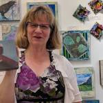 Dorolyn Alper holds up one of her encaustic pieces, a photo she took of a bald eagle thats been covered in layers of a mixture of beeswax and resin. Many of Alpers encaustic pieces incorporate monotype prints, but she also uses photographs. Alper is the artist of the month at Juneau Artists Gallery. (Ben Hohenstatt | Capital City Weekly)