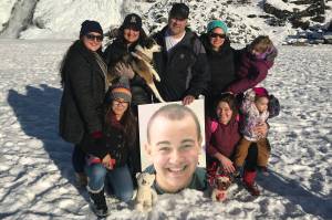 Members of the Eyre family pose at the Mendenhall Glacier with a photograph of Cody Eyre, who was shot and killed by law enforcement on Christmas Eve 2017. (Courtesy Photo | Eyre Family)