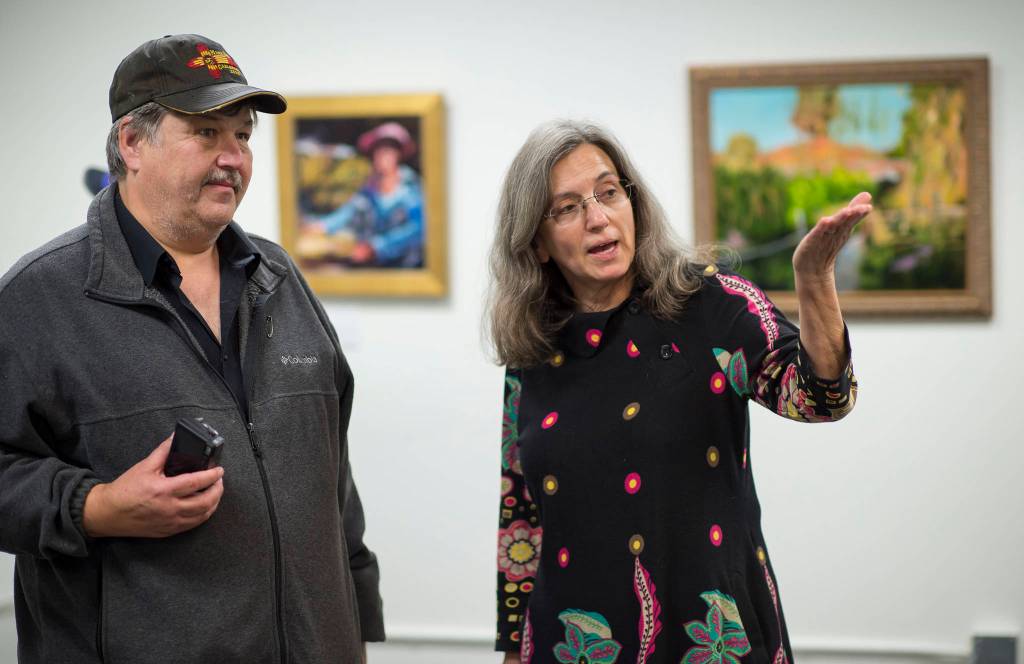 Painter Magil Pratt tells Steve Winker about her work at the Juneau Arts & Culture Center during First Friday on Friday, Sept. 7, 2018. (Michael Penn | Juneau Empire)