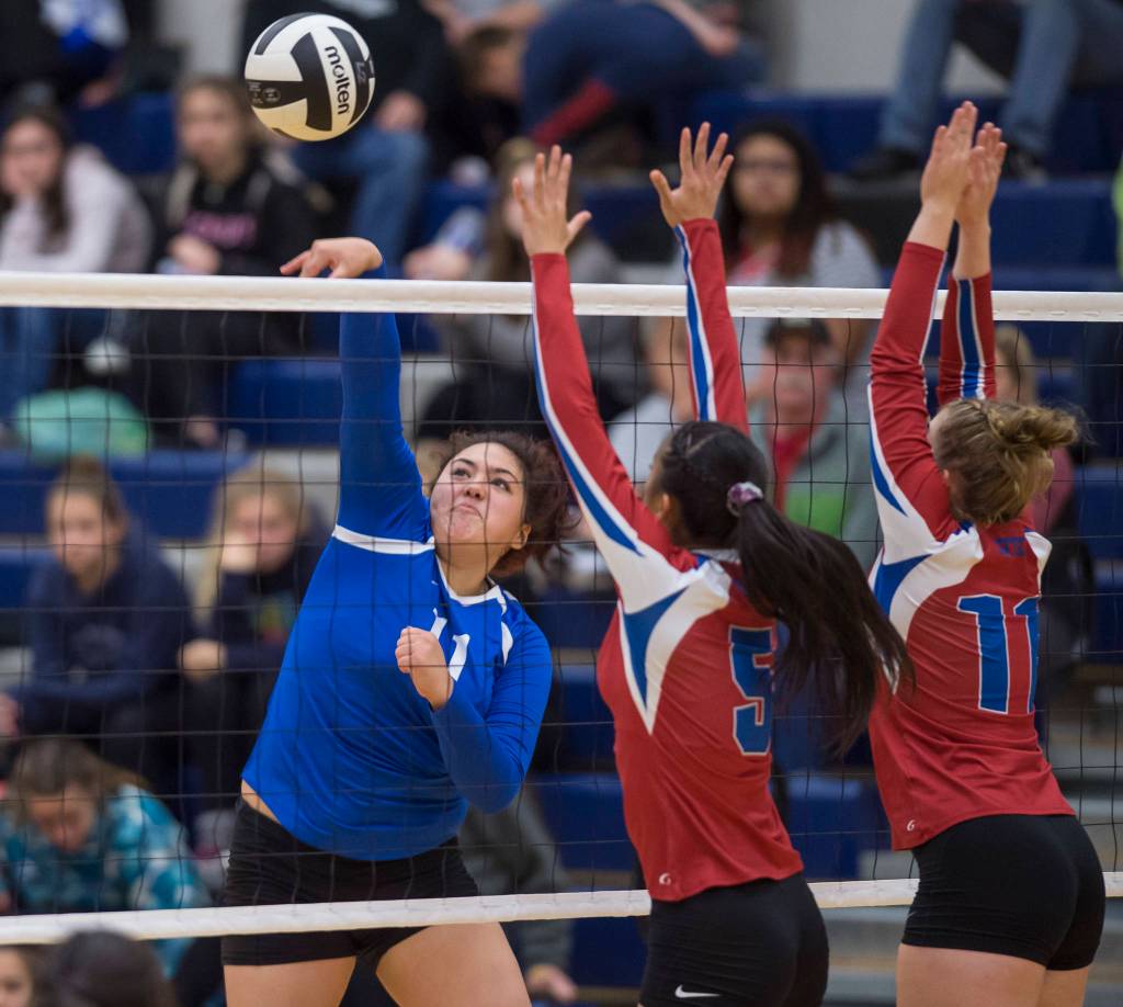 Thunder Mountains Letasiilemilion Fenumiai, left, hits against Sitkas Joei Vidad, center, and Abby Forrester at Thunder Mountain High School on Friday, Sept. 7, 2018. Thunder Mountain won 3-0 (25-15, 25-21, 25-16) (Michael Penn | Juneau Empire)