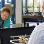 Carol Stauffer fills out paperwork while Brian Van Kirk, Thunder Mountain High School music chair, inspects a trumpet donated by Stauffer, who also donated a clarinet. Stauffers daughters played the instruments in high school, when they were Van Kirks students. (Ben Hohenstatt | Capital City Weekly)