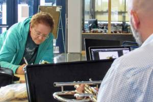 Carol Stauffer fills out paperwork while Brian Van Kirk, Thunder Mountain High School music chair, inspects a trumpet donated by Stauffer, who also donated a clarinet. Stauffers daughters played the instruments in high school, when they were Van Kirks students. (Ben Hohenstatt | Capital City Weekly)