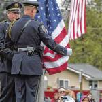 Juneau Police Department Honor Guard members Off. Mike Wise, right, and Off. Jeff Brink install the flag during the September 11 Memorial Ceremony at Rotary Park on Monday, Sept. 11, 2017. (Michael Penn | Juneau Empire File)