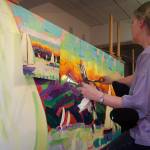 Devita Stipek Writer clutches multiple paint brushes while adapting a smaller painting for a mural-sized space. Stipek Writer, who painted several murals for Carnival Cruise Line, used larger brushes to copy the strokes that made up her oil paintings. (Courtesy Photo | Ross Writer)