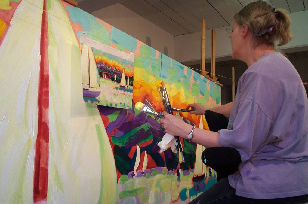 Devita Stipek Writer clutches multiple paint brushes while adapting a smaller painting for a mural-sized space. Stipek Writer, who painted several murals for Carnival Cruise Line, used larger brushes to copy the strokes that made up her oil paintings. (Courtesy Photo | Ross Writer)